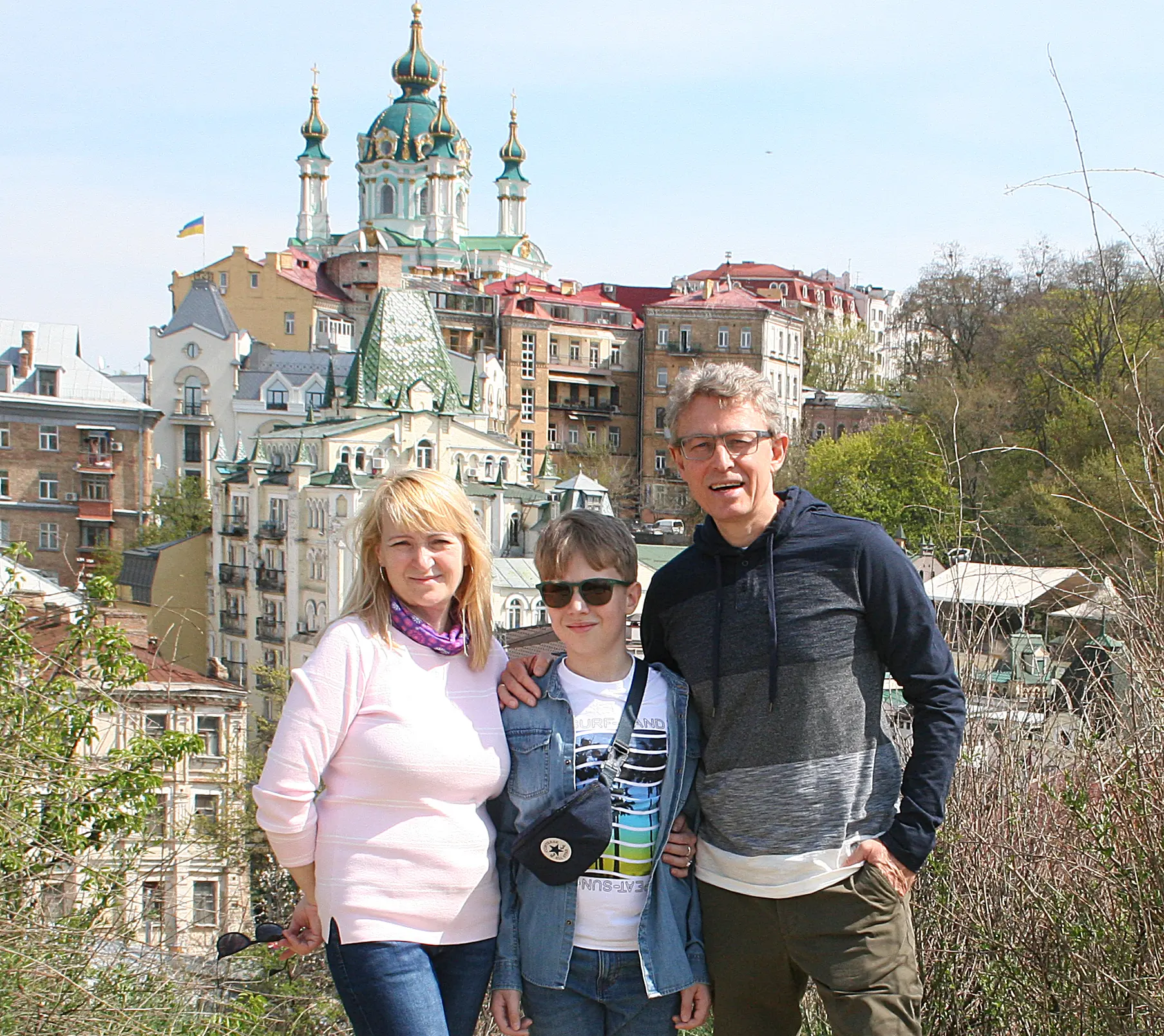 Pavlo, his wife, and son standing in front of a cathedral in Ukraine.