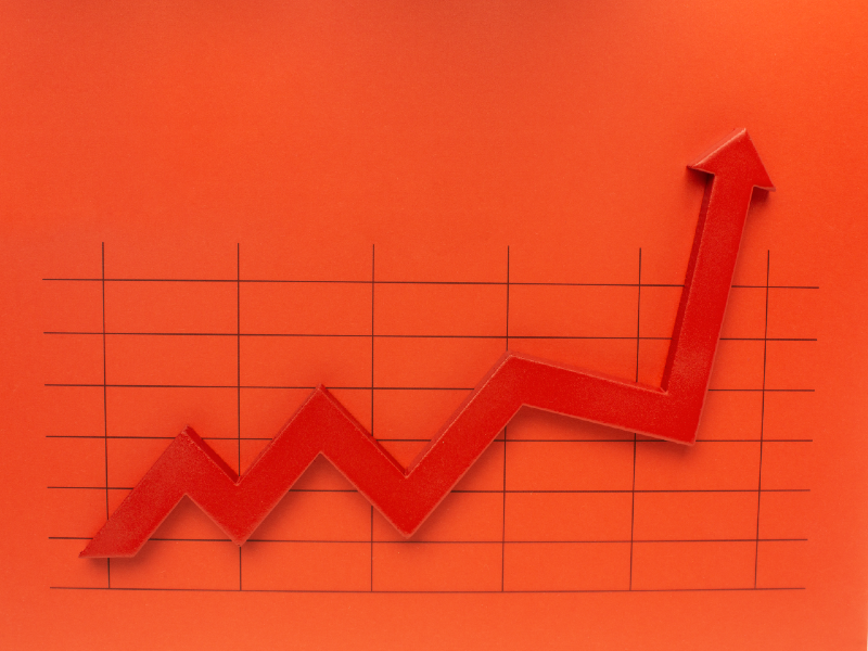 A red arrow pointing upwards on a chart against an orange background.