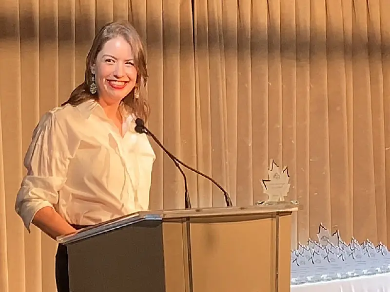 A young woman standing at a podium giving an acceptance speech