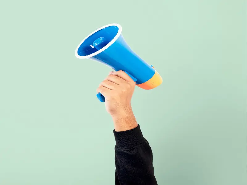 An arm of a young man holding a megaphone.