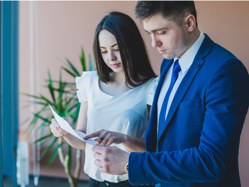 Two business professionals analyzing a document, symbolizing research and evaluation in the M&A process.