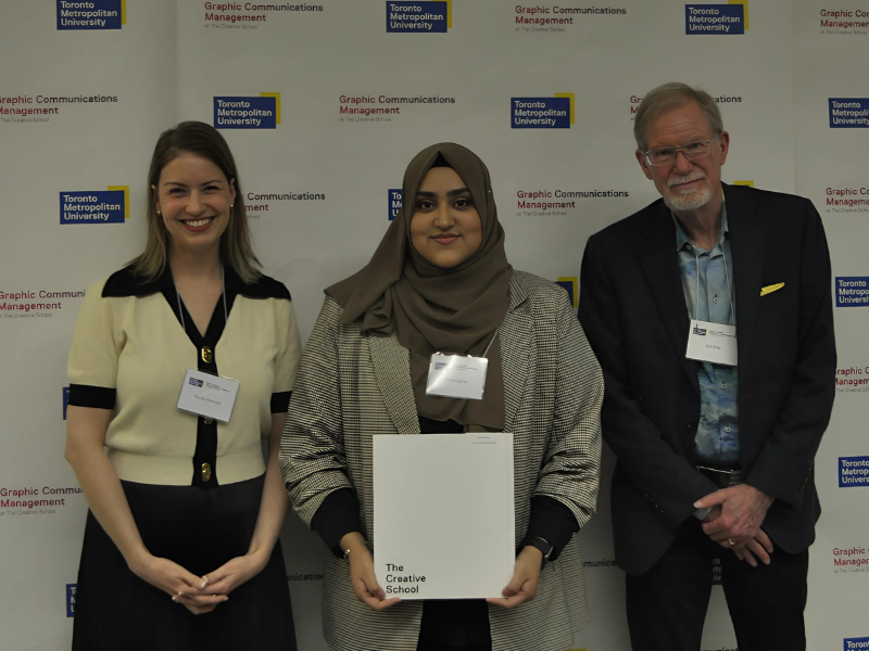 Nicole Morrison and Bob Dale presenting the Canadian Printing Industries Scholarship to student Umme Abiha at the GCM Awards Night, standing in front of a Toronto Metropolitan University backdrop.