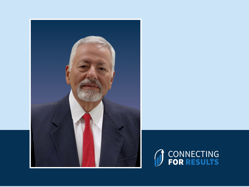 A professional headshot of Nick Howard, Advisor at Connecting for Results, wearing a navy suit, white shirt, and red tie, set against a blue gradient background.