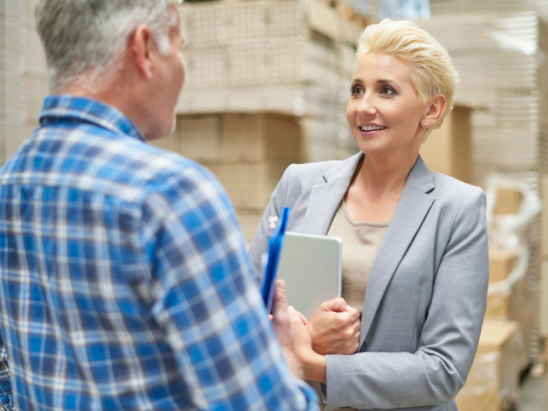 Term to permanent placement in the print industry, showing a supervisor onboarding a new team member in a warehouse setting.