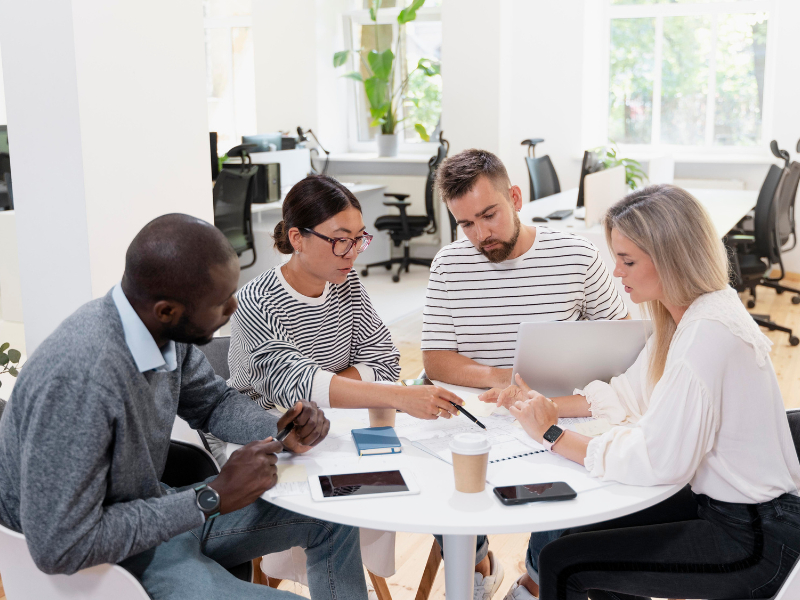 Team meeting in a modern office representing cultural integration after a business merger.