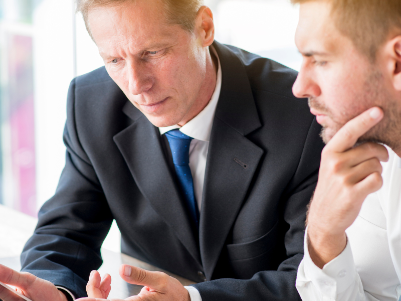 Two businessmen reviewing important financial documents during a meeting.