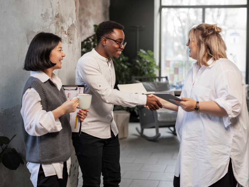 onboarding and retention the overlooked link in printing New employees and colleagues greeting each other with a handshake during an onboarding discussion in a modern workplace.