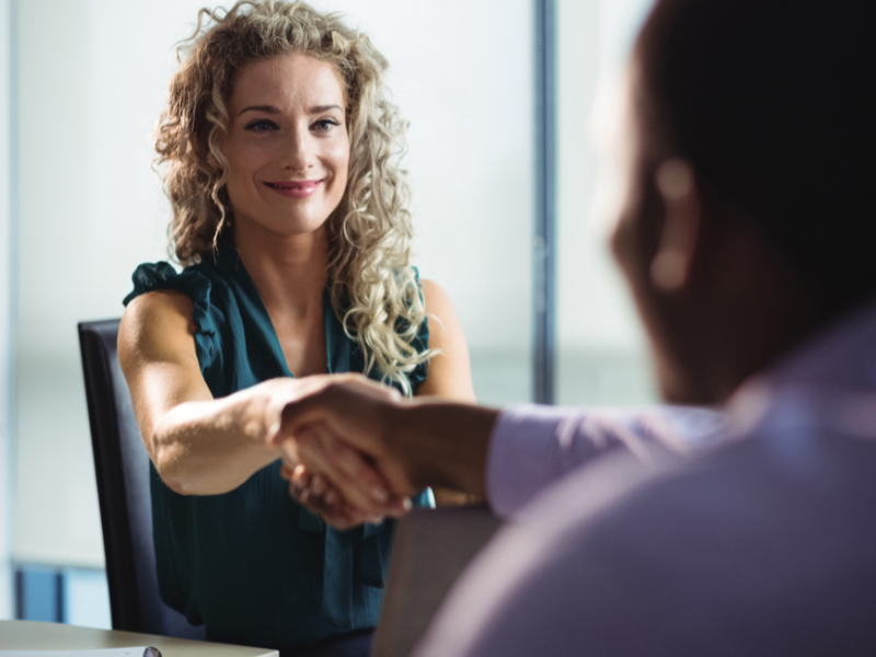 Recruiter shakes hands with candidate during an interview, reflecting successful hiring support for difficult staffing assignments.