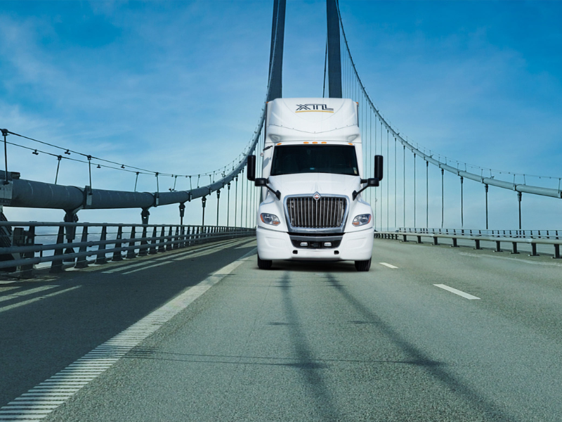 Truck crossing a suspension bridge, reflecting cross-border trade and supply chain risk for Canadian printers.