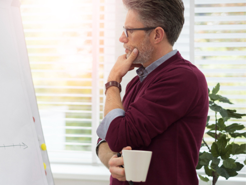 a softer labour market and skills shortage Manager reviewing plans at a whiteboard, reflecting on workforce resilience and skills shortage risk.