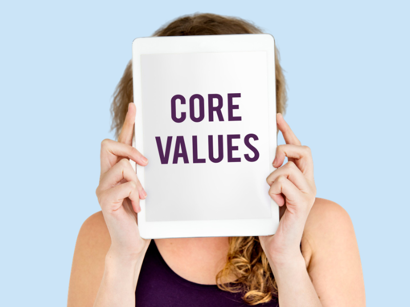 Tablet held in front of a person shows the words CORE VALUES.