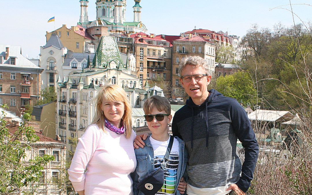 Pavlo, his wife, and son standing in front of a cathedral in Ukraine.