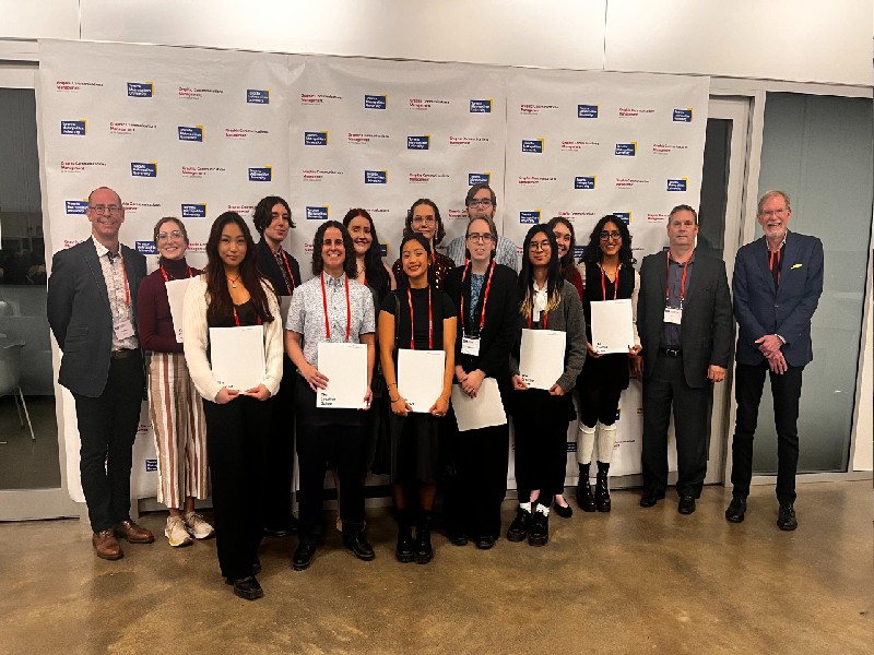 A group of students hold awards standing with 3 industry professionals.